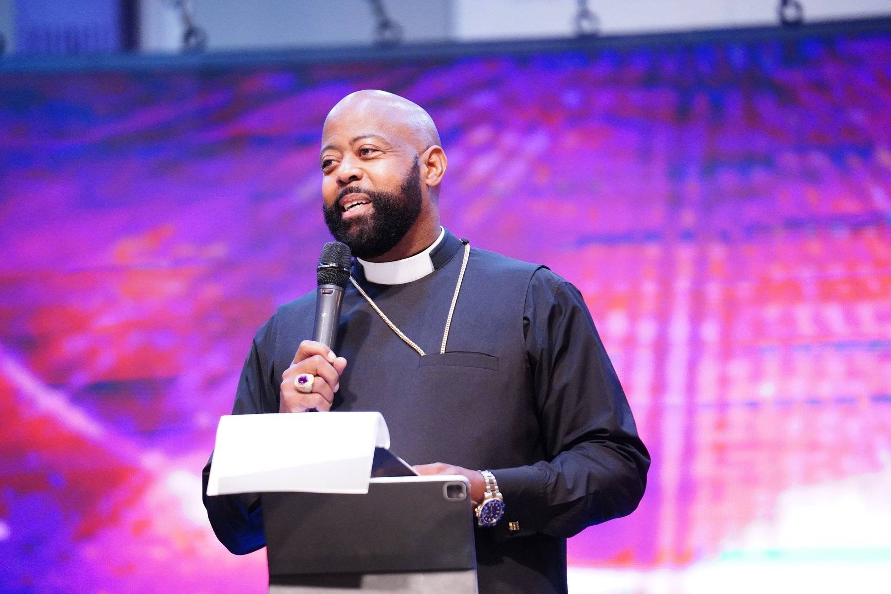 Bishop Richard Leaphart-Mack preaching under dramatic stage lighting